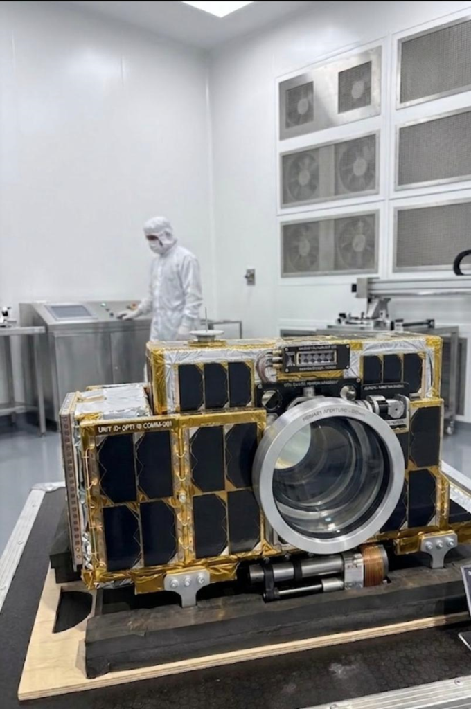 optical communication satellite. A man dress in clean room PPE